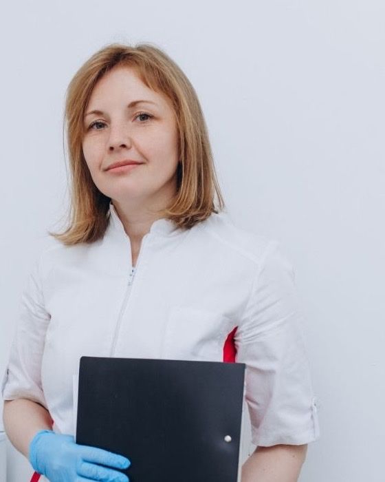 Ольга Василівна Герасимчук у медичному костюмі з папкою в руках